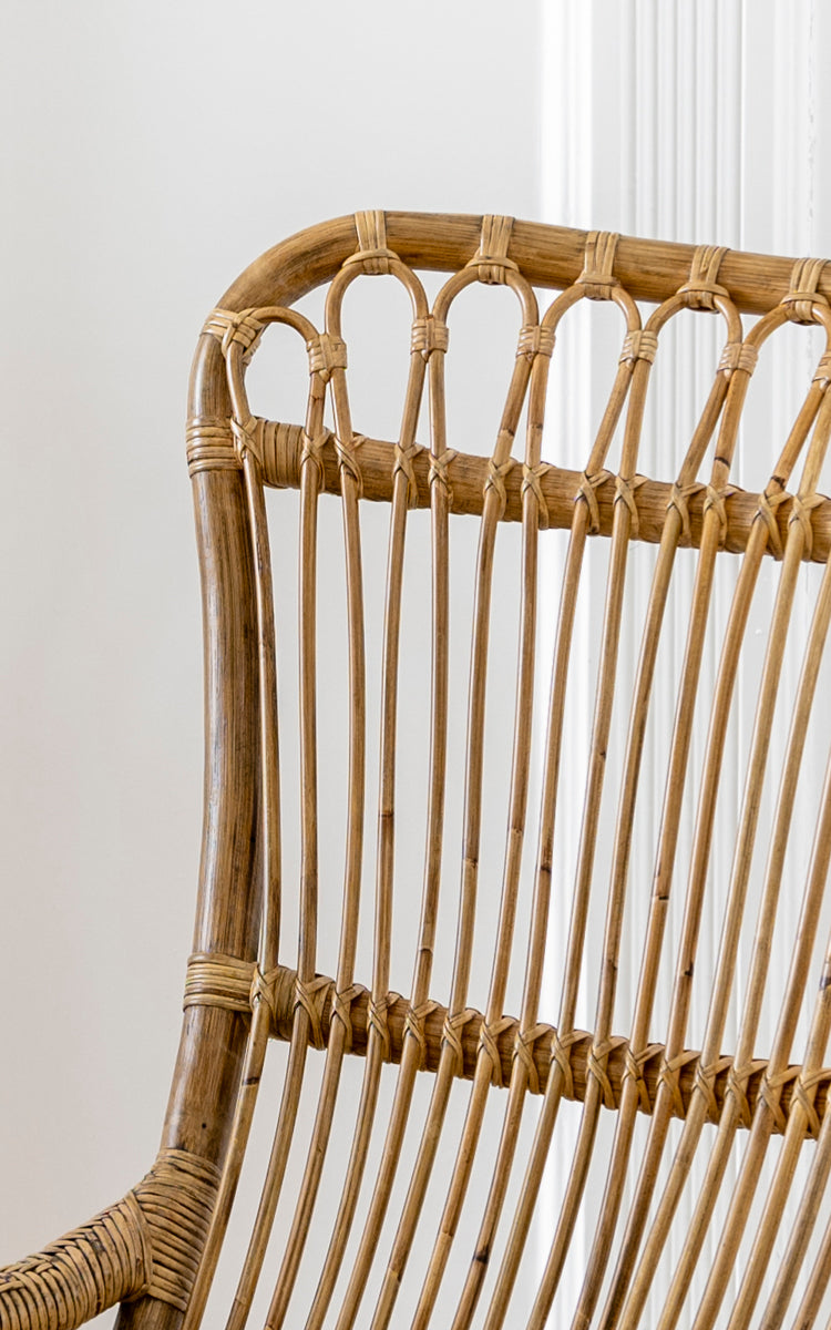 Esta es una imagen de detalle de Monet Rocking Chair i antique rattan. Detalle del respaldo de arcos en bucle y la construcción de varillas verticales de ratán.