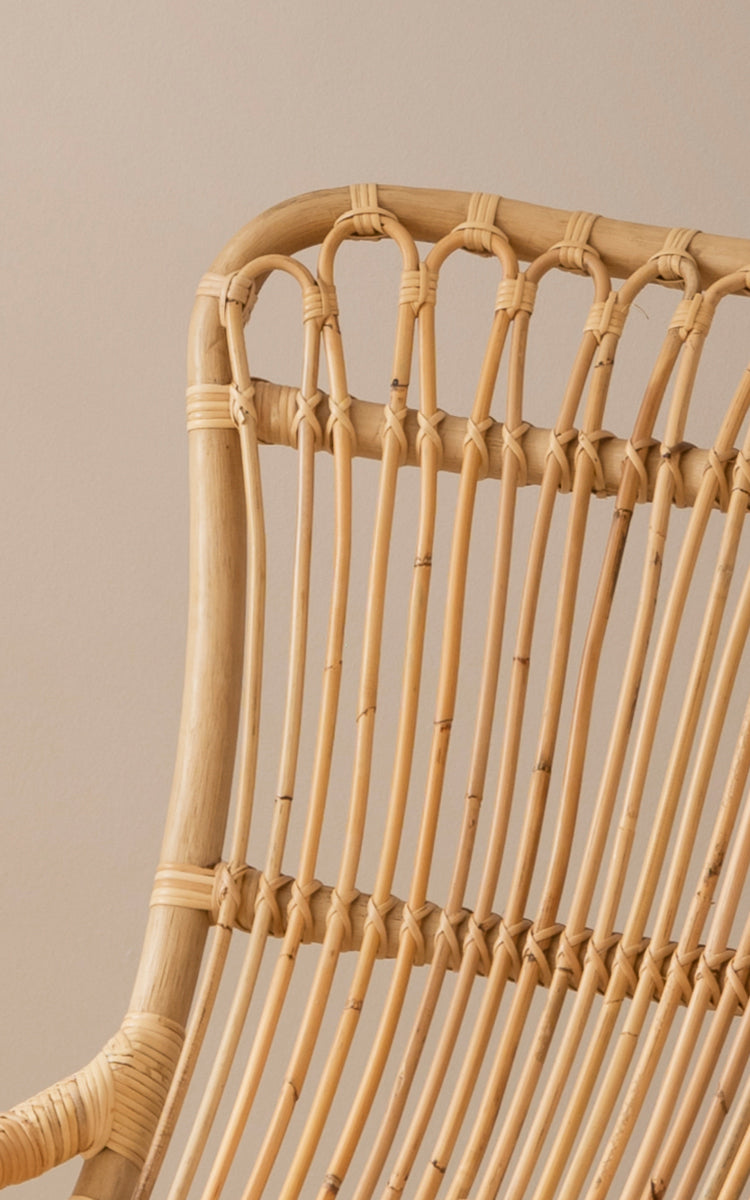 Esta es una imagen de detalle de Monet Rocking Chair i natural rattan. Detalle del diseño de arcos en bucle y el tejido de ratán envuelto en la parte superior.