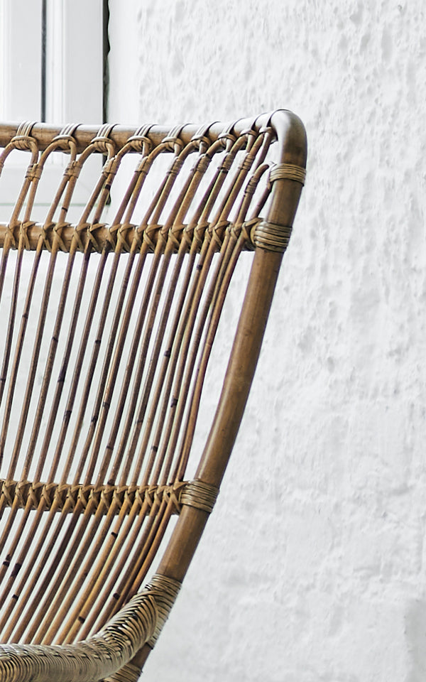 Esta es una imagen de detalle de Monet Lounge Chair i antique rattan. Detalle del respaldo de arcos en bucle con varillas verticales y asiento tejido.