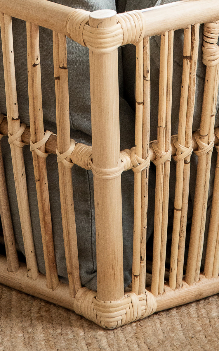 Esta es una imagen de detalle de Marche cesta en natural rattan. Varillas verticales de ratán con juntas envueltas y construcción abierta de listones.