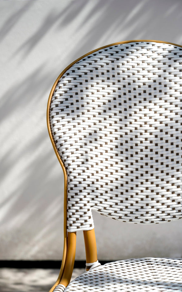 Esta es una imagen de detalle de Isabell silla de comedor exterior en almond aluminium frame white w cappuccino dot artfibre. Respaldo ovalado tejido bajo la luz del sol.