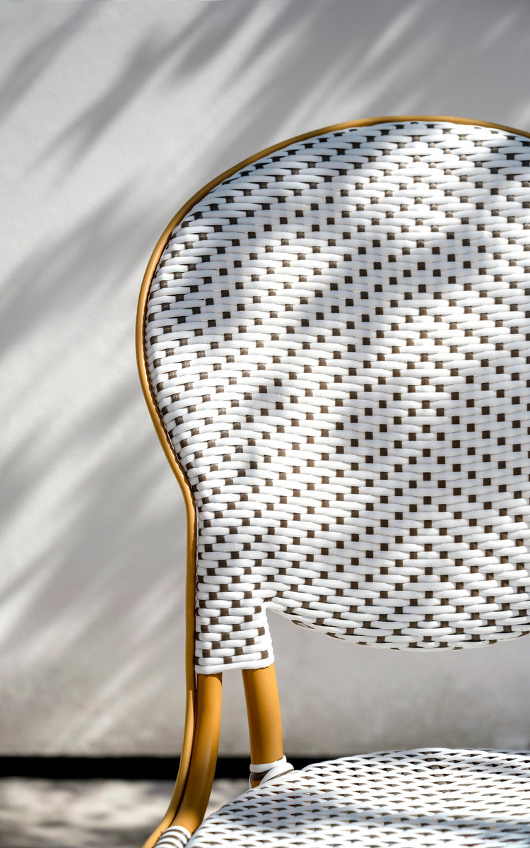 Esta es una imagen de detalle de Isabell silla de comedor exterior en almond aluminium frame white w cappuccino dot artfibre. Respaldo ovalado tejido bajo la luz del sol.