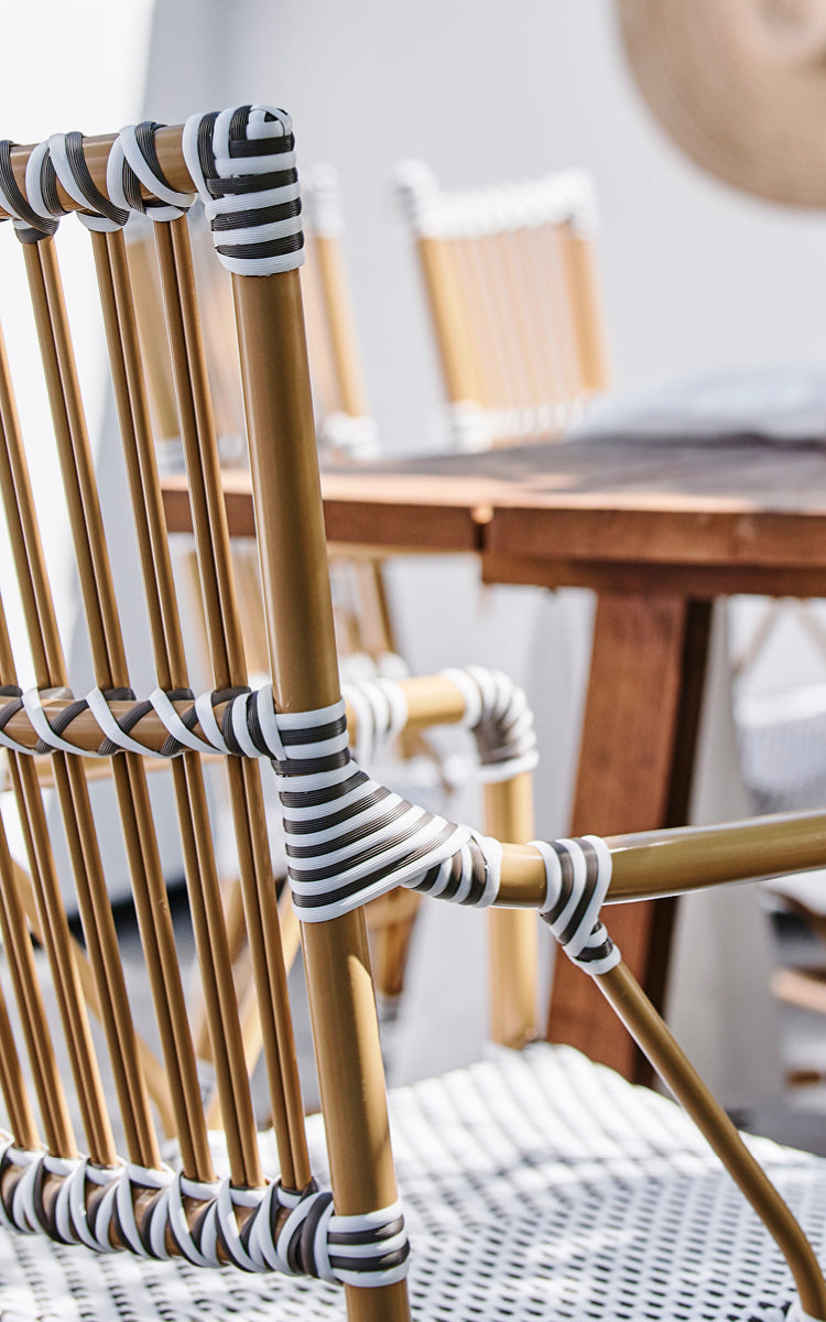 Esta es una imagen de detalle de Monique Exterior Dining Armchair i white w cappuccino dot ArtFibre. Detalle del tejido de puntos y el reposabrazos.