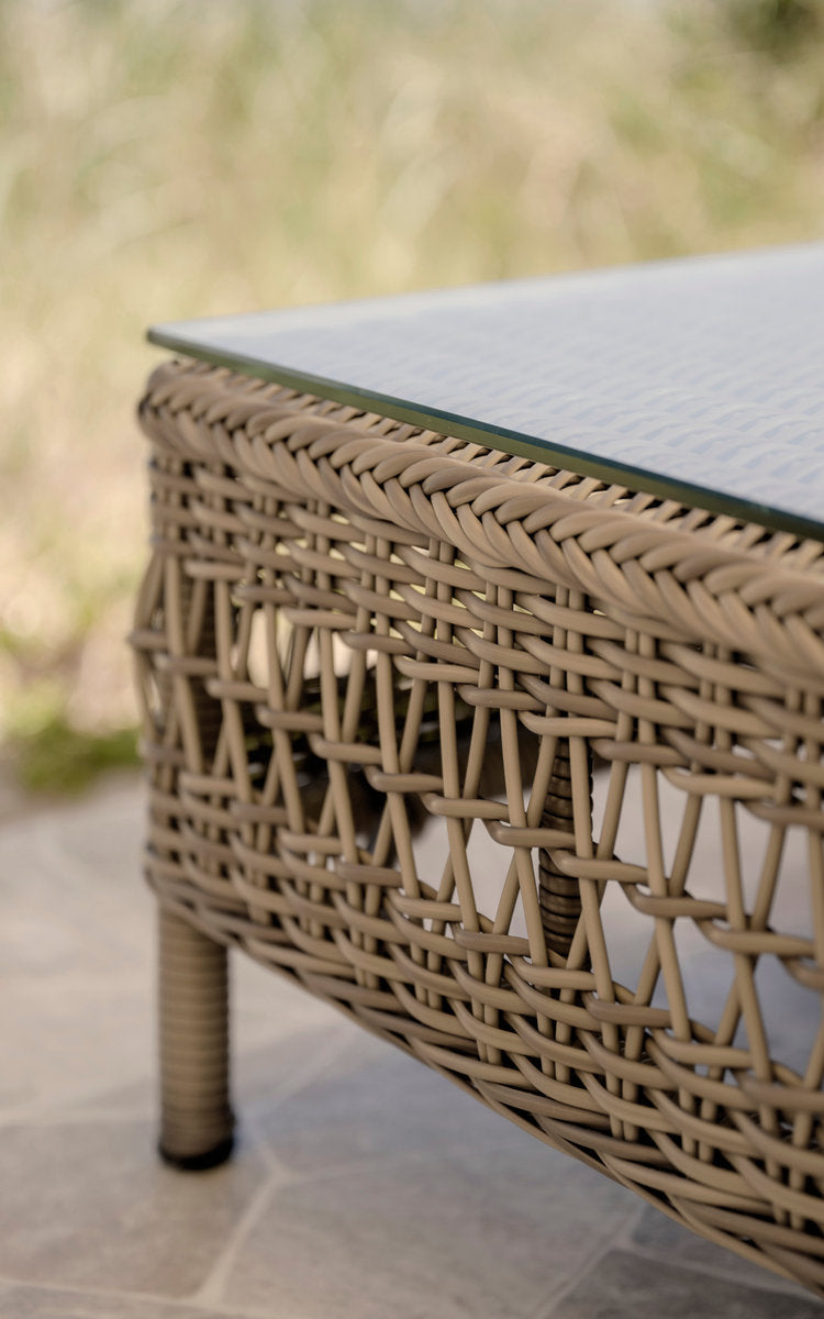 Esta es una imagen de detalle de Mona sofá modular exterior-Pouf Module w. Glass en antique grey artfibre aluminium. Tejido abierto bajo un tablero de cristal.