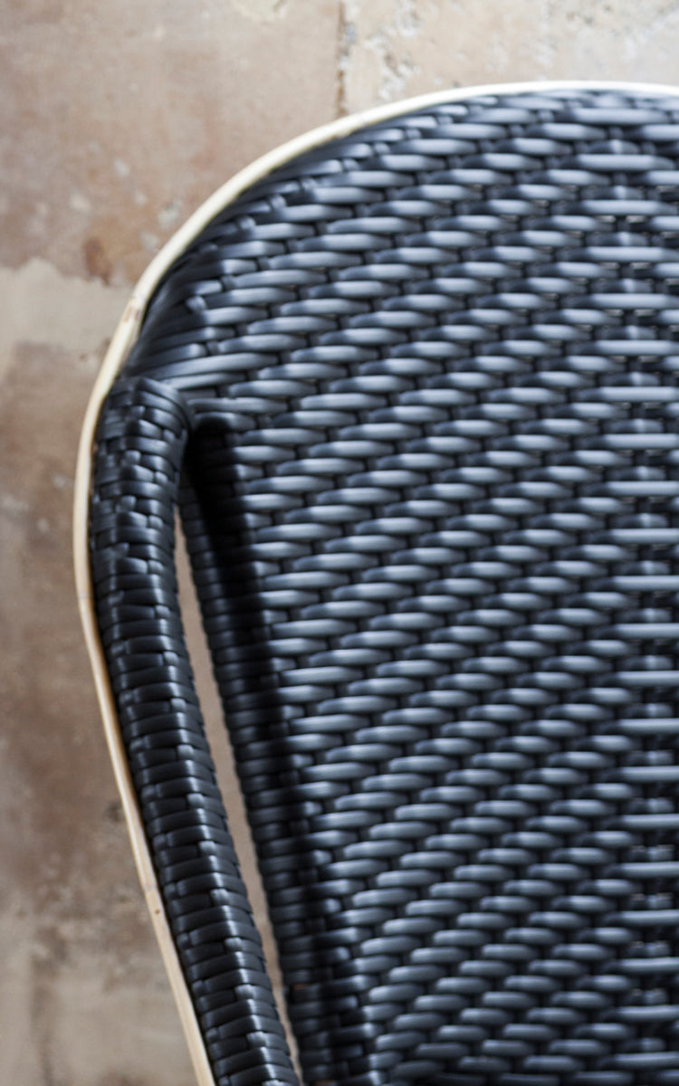 Esta es una imagen de detalle de Sofie silla de comedor en black artfibre skin on rattan frame. Detalle de la textura tejida y construcción de la estructura.