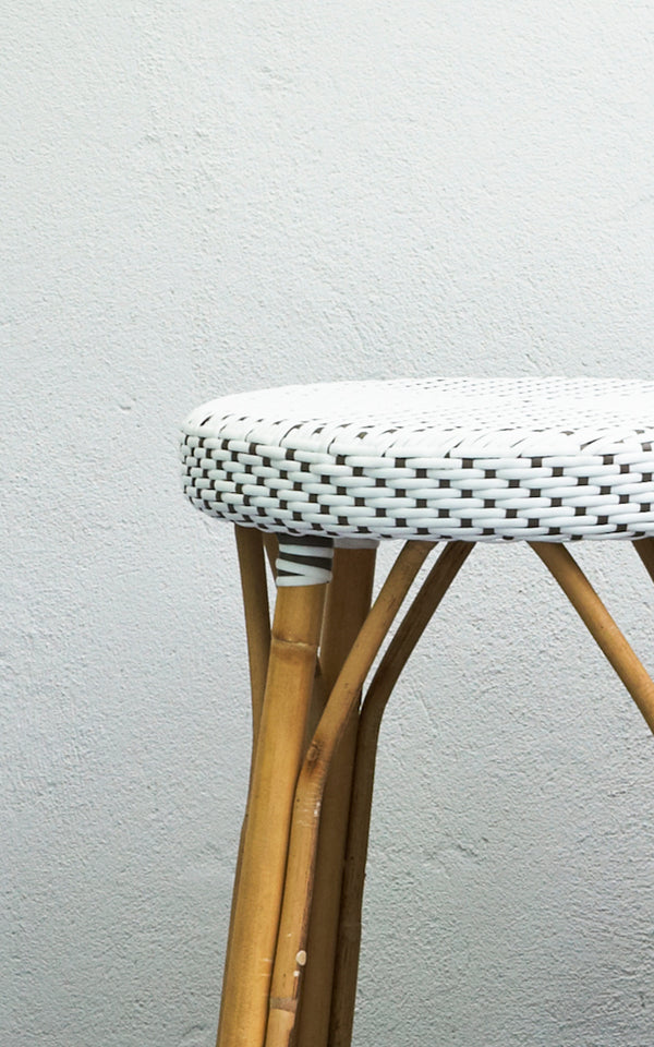 Esta es una imagen de detalle de Simone taburete alto en white w cappuccino dot ArtFibre Skin on Rattan frame. Junto a una pared blanca.