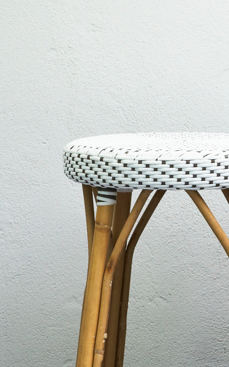 Esta es una imagen de detalle de Simone taburete alto en white w cappuccino dot ArtFibre Skin on Rattan frame. Junto a una pared blanca.
