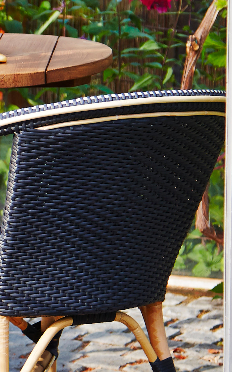 Esta es una imagen de detalle de Madeleine silla de comedor en black ArtFibre skin on rattan frame. Tejido negro denso con borde de marco de ratán.