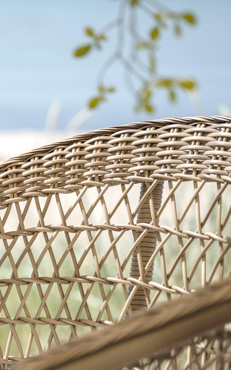 Esta es una imagen de detalle de Emma taburete de bar exterior en antique grey artfibre aluminium. Respaldo de tejido abierto en rombos junto al mar.