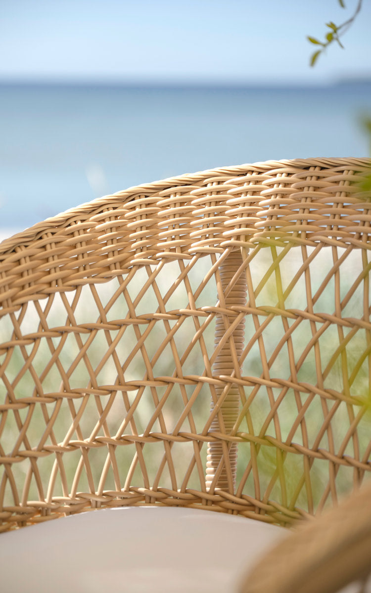Esta es una imagen de detalle de Emma taburete de bar exterior en natural artfibre aluminium. Respaldo de tejido abierto con vista al mar.