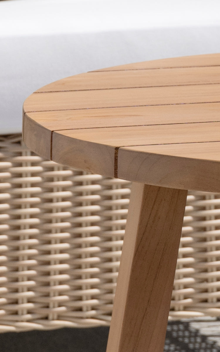 Esta es una imagen de detalle de Victor Teak Lounge Table Ø75 cm en teak outdoor. Detalle del borde del tablero redondo de tablones de teca y la pata cónica.