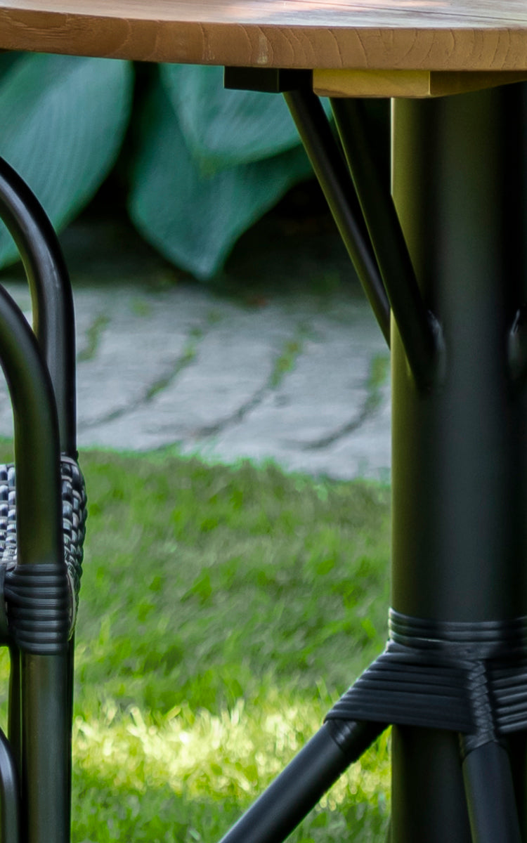 Esta es una imagen de detalle de Nicole Cafe Table i black aluminium frame black ArtFibre. Detalle del tablero de teca y la base envuelta.