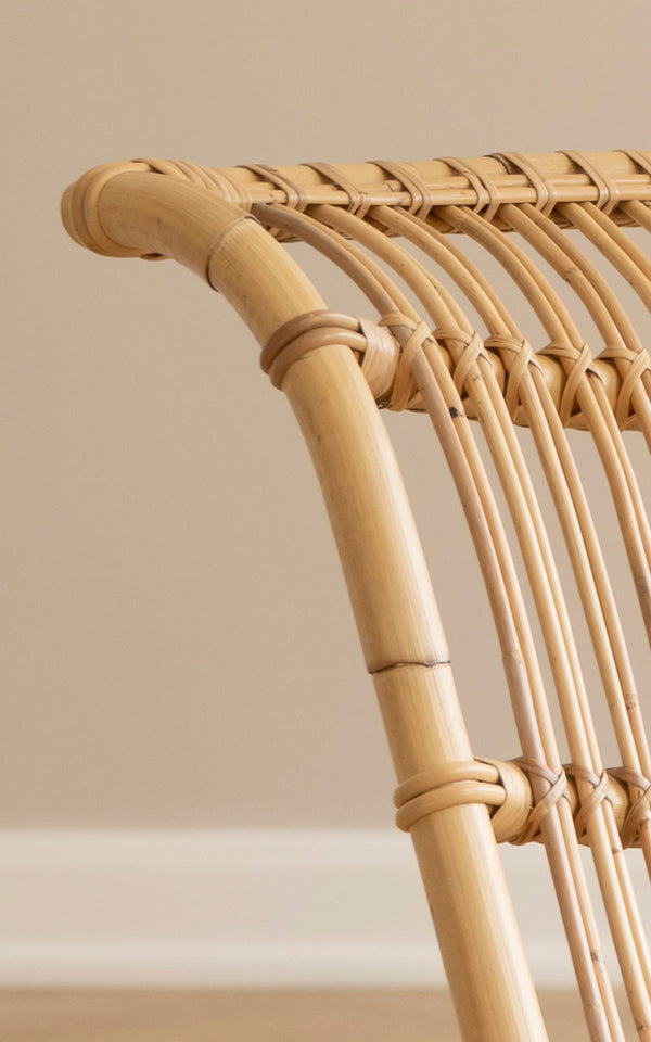 Esta es una imagen de detalle de Paris sillón lounge en polished natural rattan. Detalle de la estructura curva de ratán y listones arqueados del asiento.