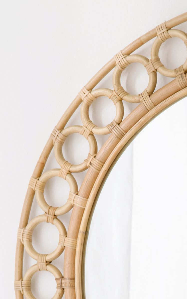 Esta es una imagen de detalle de Mira Mirror i natural rattan. Detalle del borde circular de anillos de ratán que enmarca el espejo redondo.