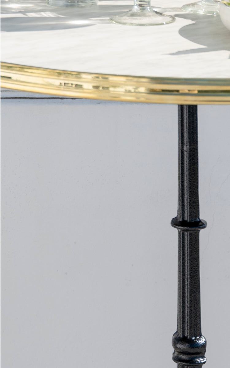 Esta es una imagen de detalle de Lyon mesa de bar Versalite Marble Ø70 cm en cast iron. Tapa de mármol y columna de hierro fundido con perfil torneado.