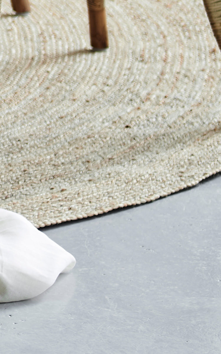 Esta es una imagen de detalle de Jute Carpet Ø280 en grey jute. La textura tejida y el borde redondeado se muestran sobre un suelo de hormigón.