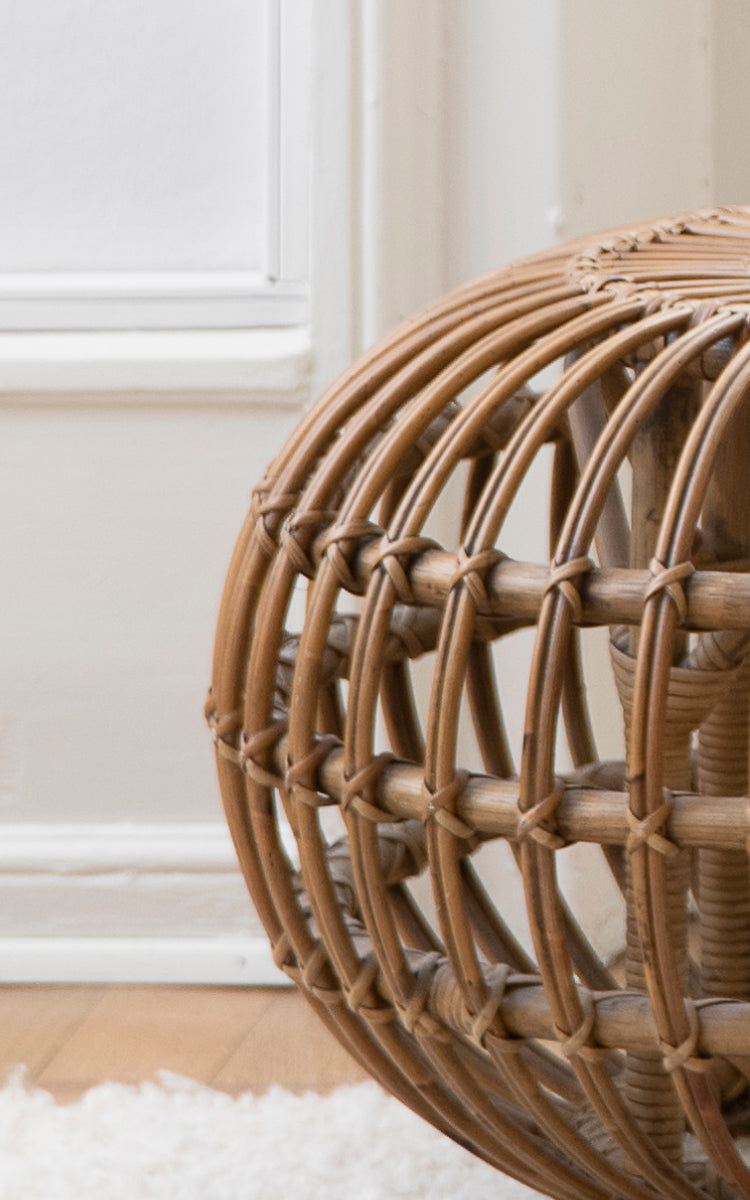 Esta es una imagen de detalle de Ottoman Small en polished antique rattan. Detalle de la estructura de jaula de ratán abierta con atados cruzados.