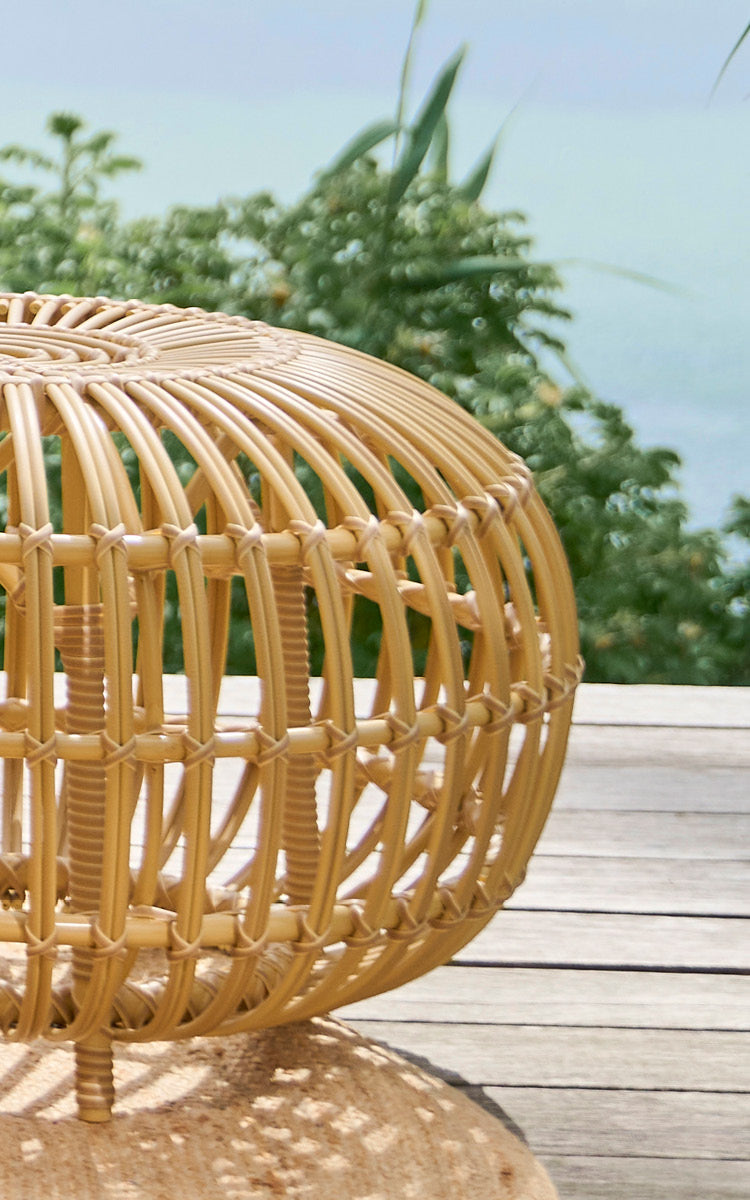 Esta es una imagen de detalle de FA-E16-NU Ottoman Exterior en natural aluminium artfibre. Detalle del otomana tejida de ArtFibre con costillas curvas en una terraza.