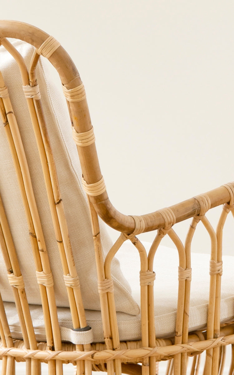 Esta es una imagen de detalle de Tulip sillón lounge en polished natural rattan. Detalle de la estructura de ratán, refuerzos arqueados y cojín de lino.