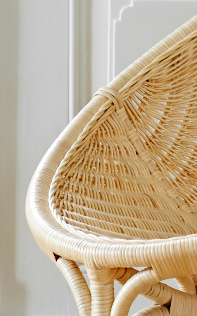 Esta es una imagen de detalle de Rana sillón lounge en natural core weave rattan frame. Detalle del asiento tejido en forma de concha y borde curvo de la estructura de ratán.