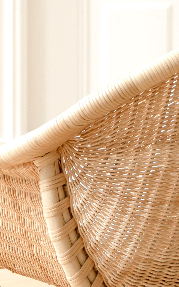 Esta es una imagen de detalle de Madame sillón lounge en natural core weave rattan frame. Detalle de respaldo de ratán finamente tejido con luz suave.