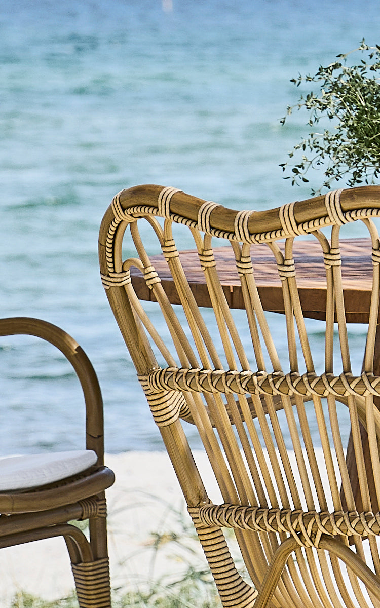 Esta es una imagen de detalle de Margret sillón de comedor exterior en antique aluminium artfibre. Respaldo curvado con ArtFibre envuelto y fondo marino.