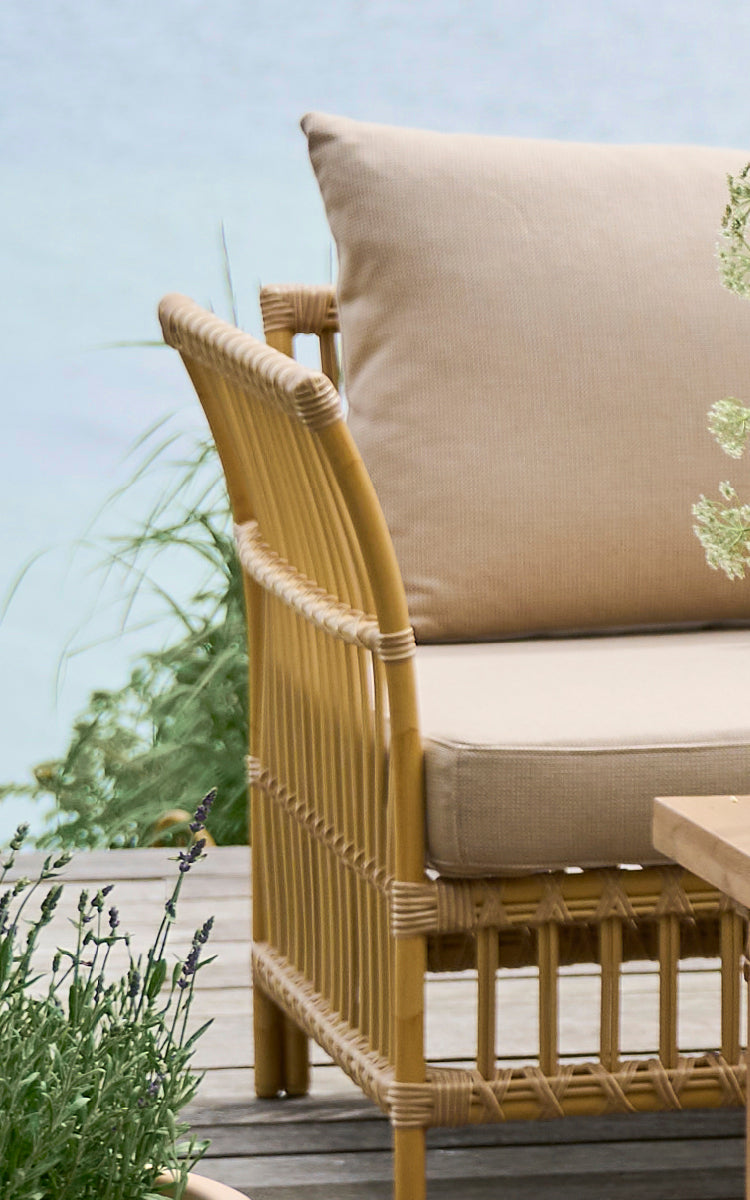 Esta es una imagen de detalle de Maggie Sofá Módulo Esquinero en natural aluminium artfibre. Marco de listones verticales con juntas envueltas y cojín beige.