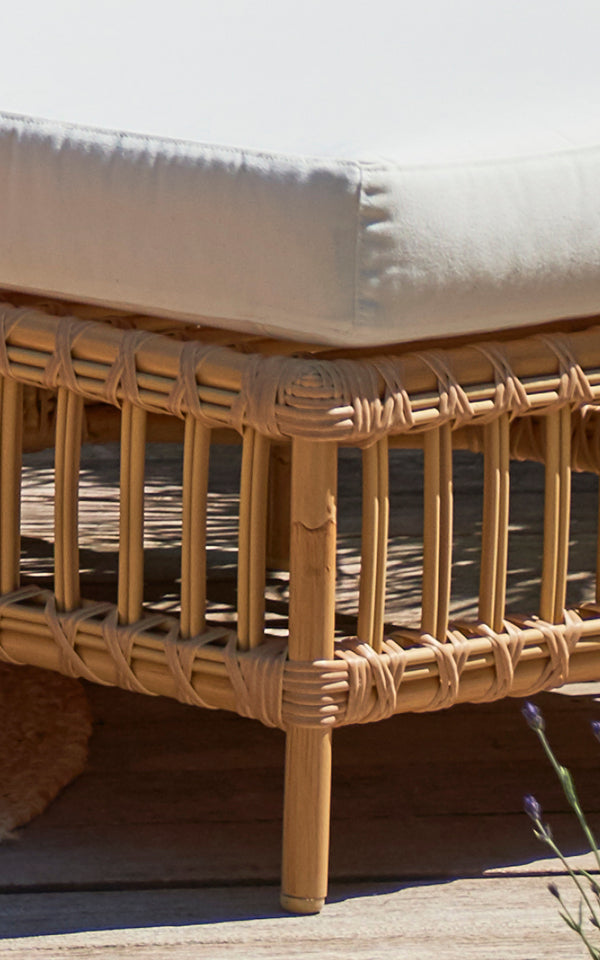 Esta es una imagen de detalle de Maggie Sofá Módulo Puf c. Cristal en natural aluminium artfibre. Cojín sobre marco de ratán con detalle de listones envueltos.