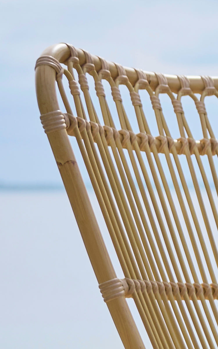 Esta es una imagen de detalle de Monet Exterior Lounge Chair i natural aluminium artfibre. Detalle de los arcos en bucle y el asiento de varillas.