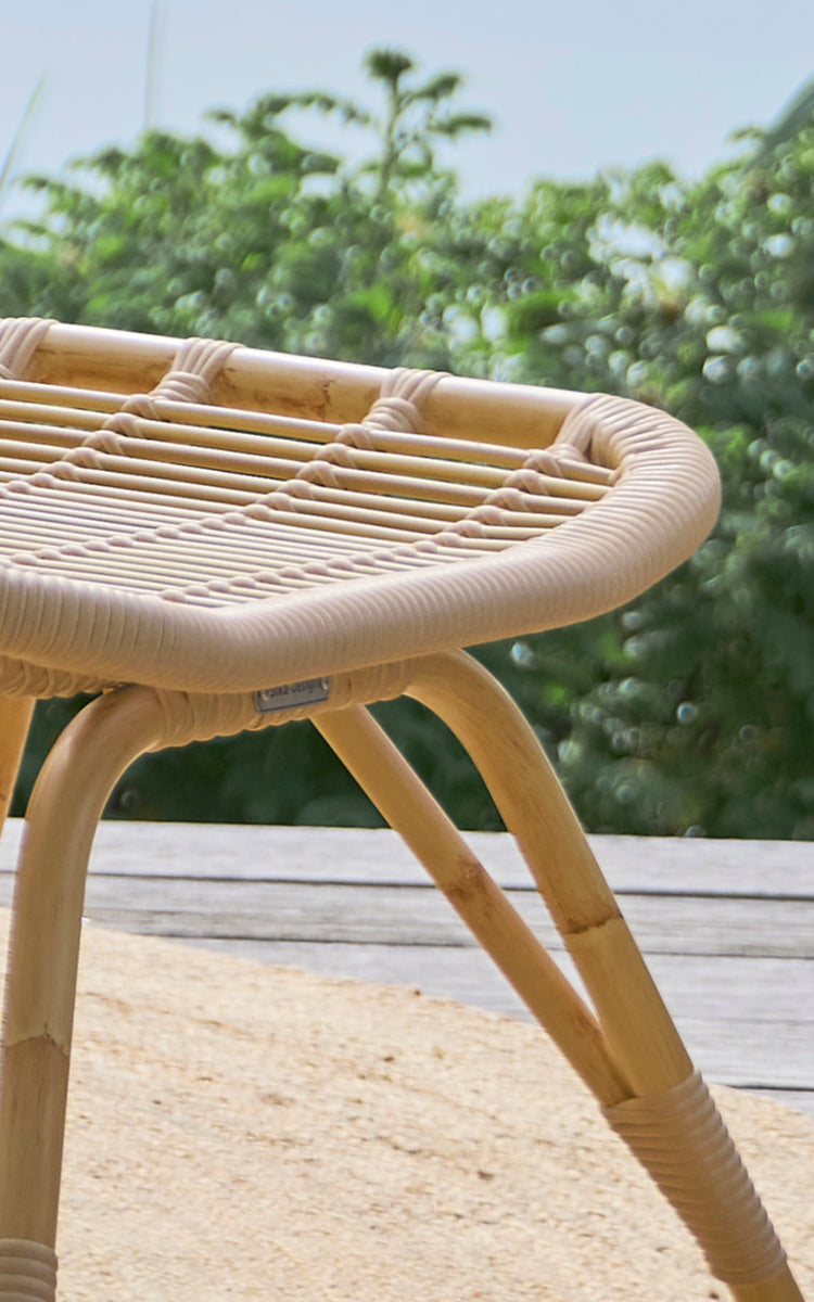 Esta es una imagen de detalle de Monet Exterior Footstool i natural aluminium artfibre. Detalle del asiento tejido y las patas abiertas.