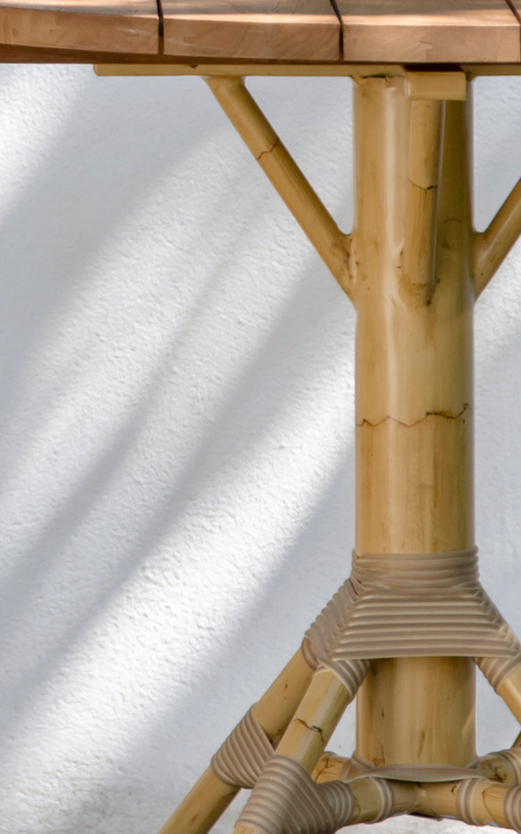 Esta es una imagen de detalle de Nicole Cáfe Table | Teak Ø80 cm en natural aluminium artfibre. Detalle de la textura tejida y construcción de la estructura.