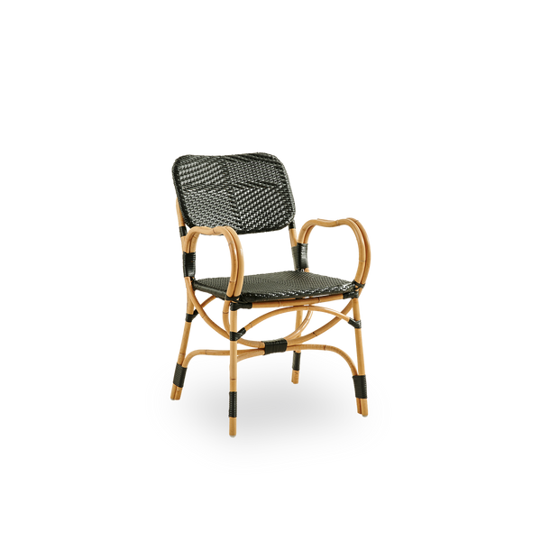 Vista lateral de la silla Bistro en tejido ArtFibre negro con diseño elegante. Estructura de ratán con asiento tejido en ArtFibre. La estructura curva de ratán bajo el asiento se extiende hasta formar los reposabrazos.