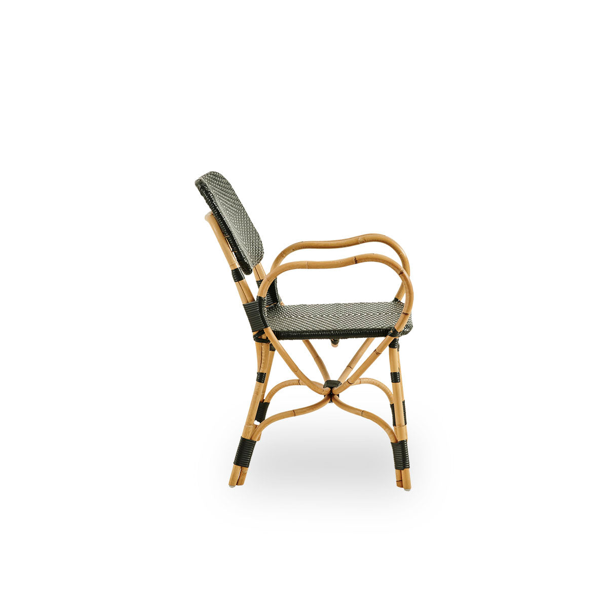 Vista lateral simple de la silla Bistro en tejido ArtFibre negro con diseño elegante. Estructura de ratán con asiento tejido en ArtFibre. La estructura curva de ratán bajo el asiento se extiende hacia los reposabrazos.