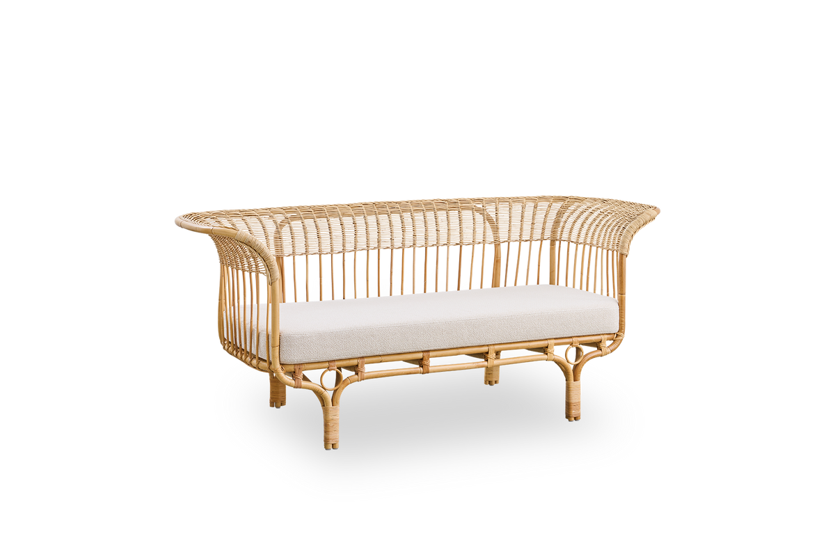 Vista lateral del sofá Belladonna en ratán natural, diseñado por Franco Albini y Franca Helg. El sofá tiene una expresión elegante con patas delgadas y un asiento majestuoso con numerosos detalles de tejido.