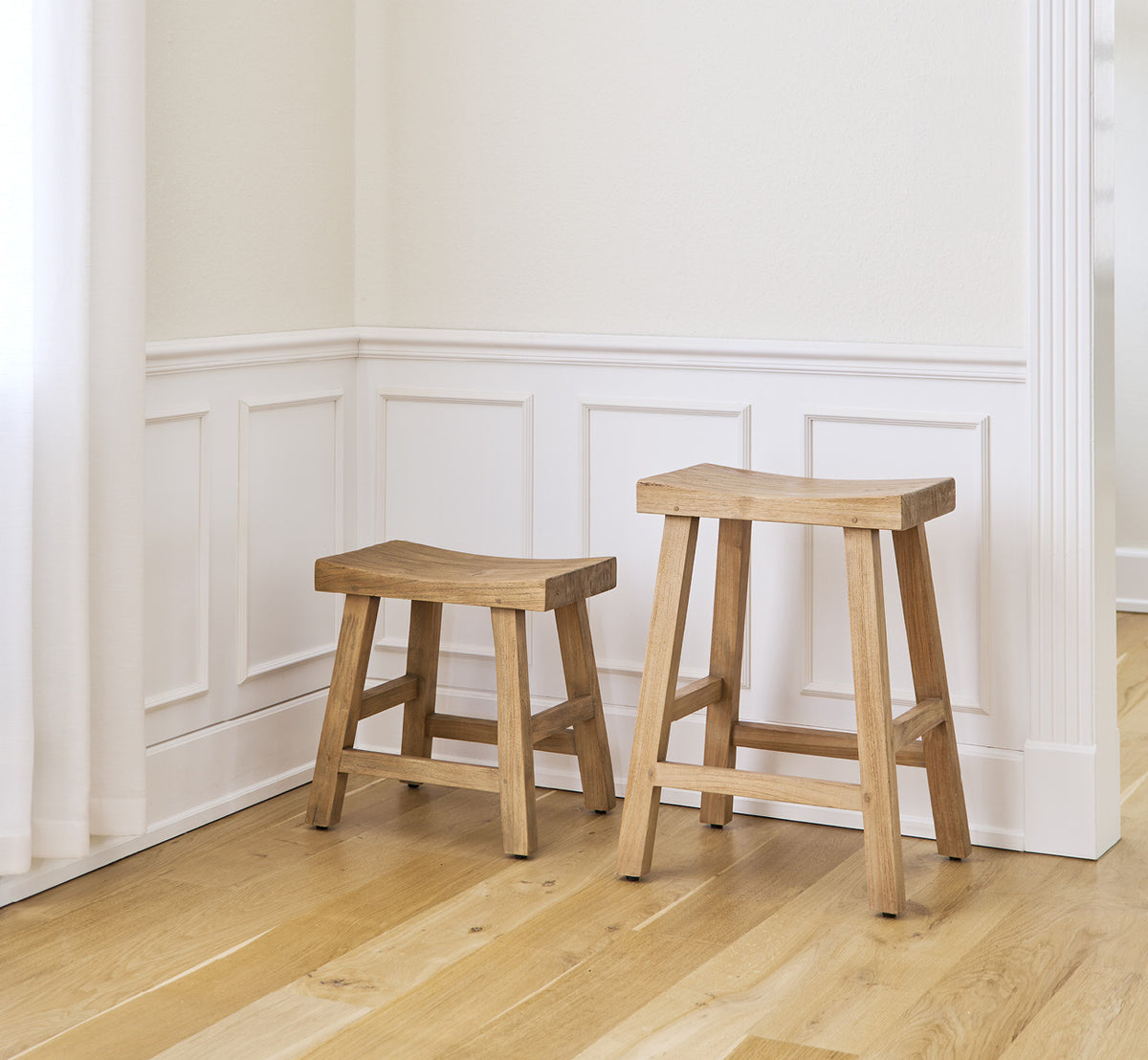 Esta es una imagen de estilo de vida de Charles taburete en teak indoor, en un interior blanco y luminoso con revestimiento de pared y parqué en.