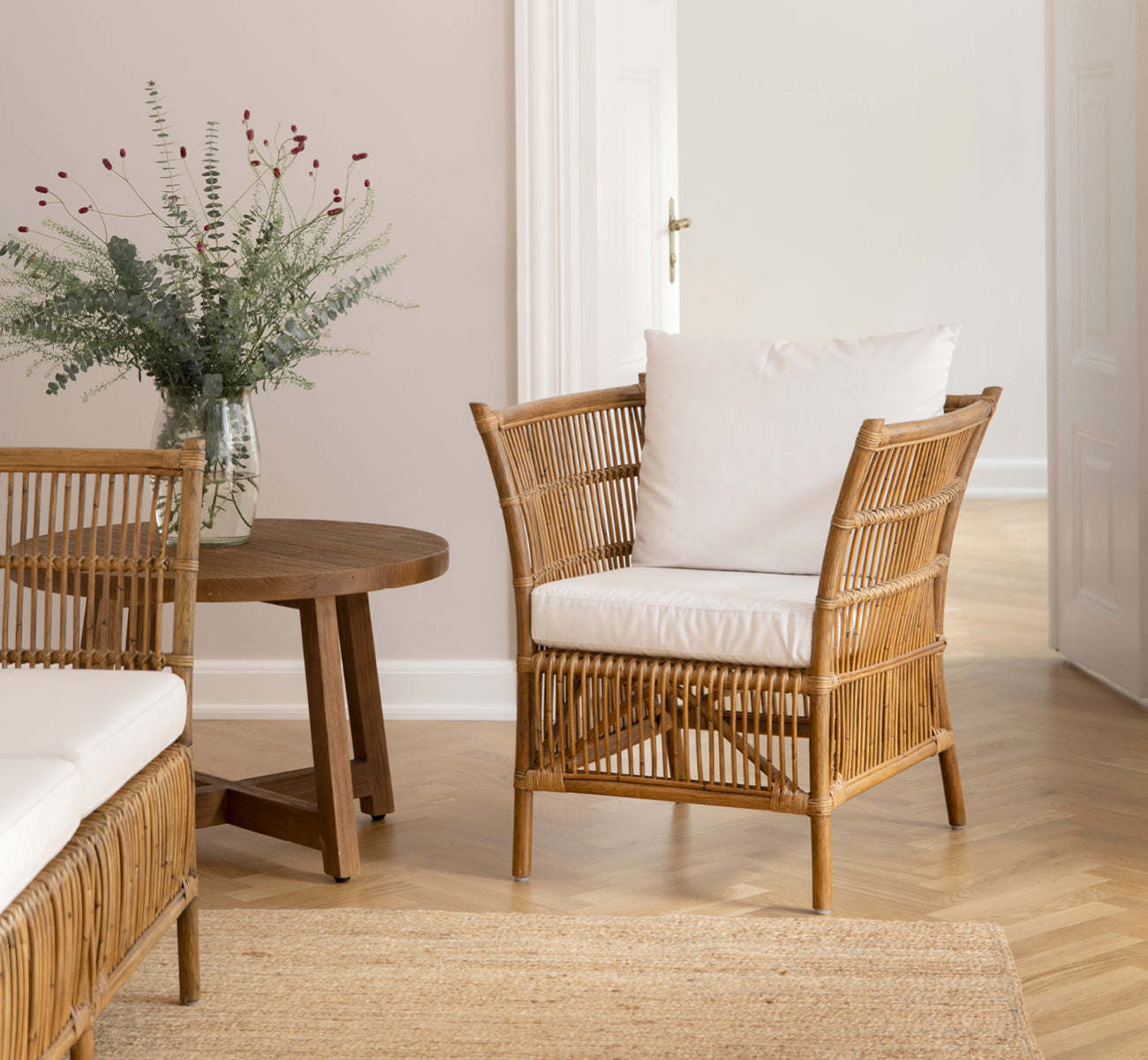 Esta es una imagen de estilo de vida de Donatello sillón lounge en antique rattan, en una luminosa sala de estar con parqué en espiga y exuberante.