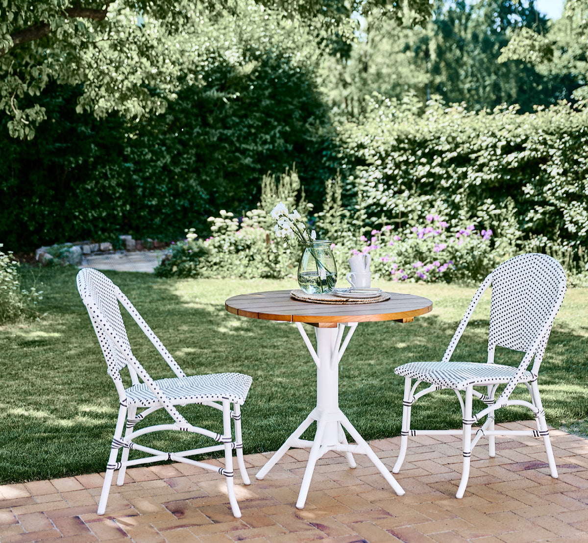 Esta es una imagen de estilo de vida de Sofie silla de comedor exterior en white aluminium frame white w cappuccino dot artfibre.