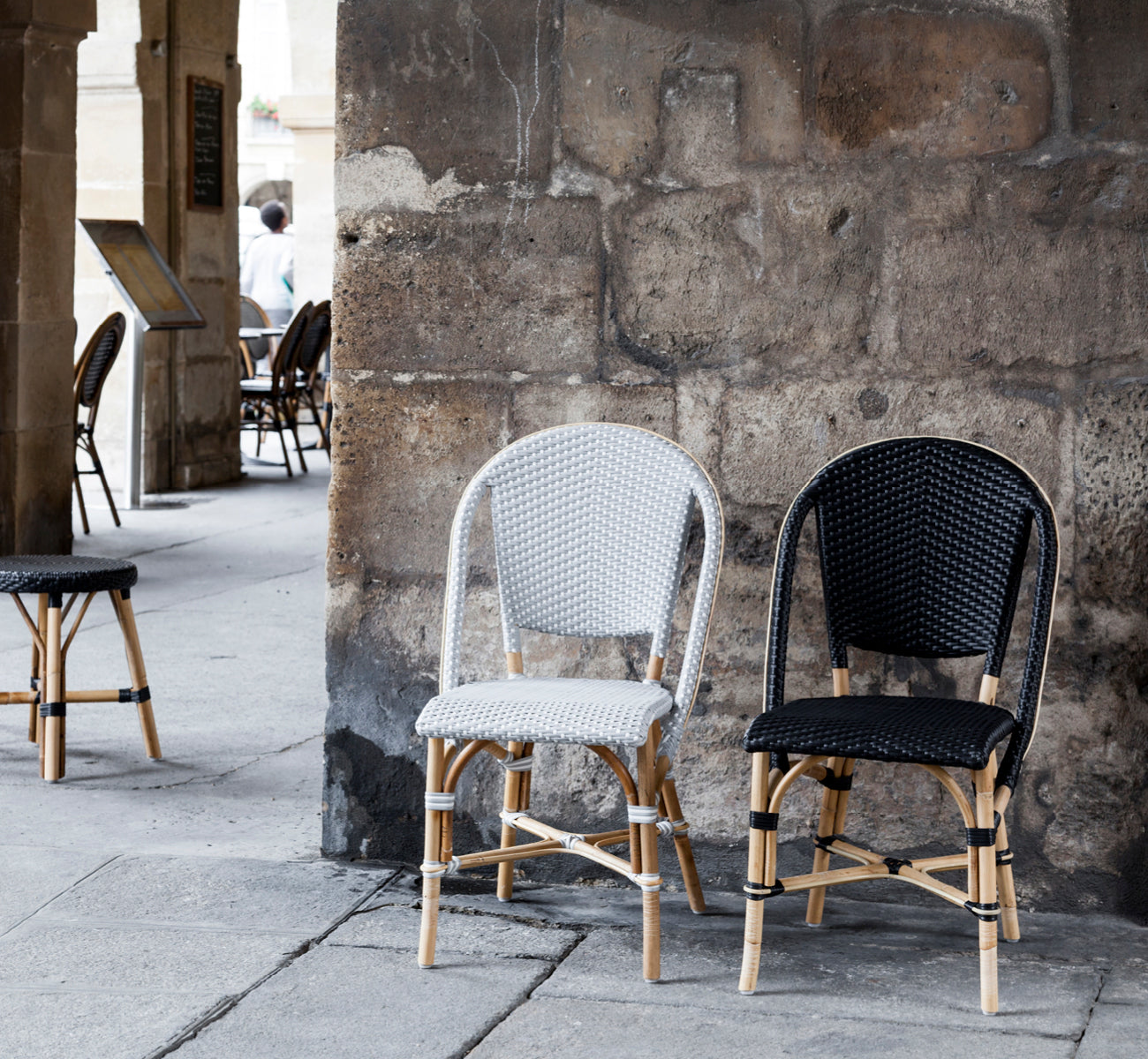 Esta es una imagen de estilo de vida de Sofie silla de comedor en black artfibre skin on rattan frame. Estilizado en un interior luminoso.