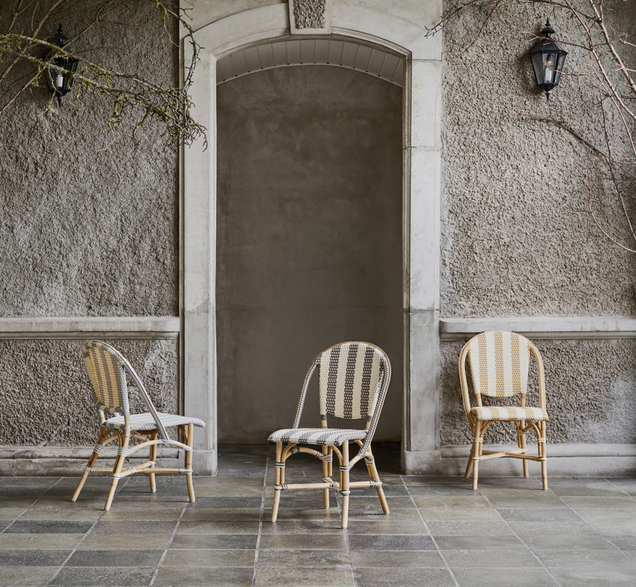 Esta es una imagen de estilo de vida de Sofie silla de comedor en striped cappuccino ivory artfibre skin on natual rattan frame. Estilizado en un interior luminoso.