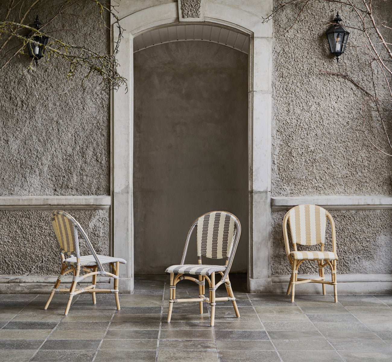 Esta es una imagen de estilo de vida de Sofie silla de comedor en striped honey ivory artfibre skin on natual rattan frame. Estilizado en un interior luminoso.