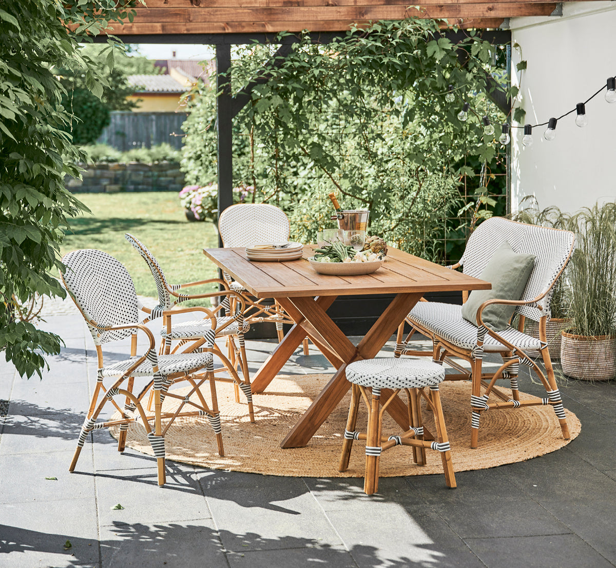 Esta es una imagen de estilo de vida de Isabell sillón de comedor en white w cappuccino dot ArtFibre Skin on Rattan frame, en un luminoso comedor con.