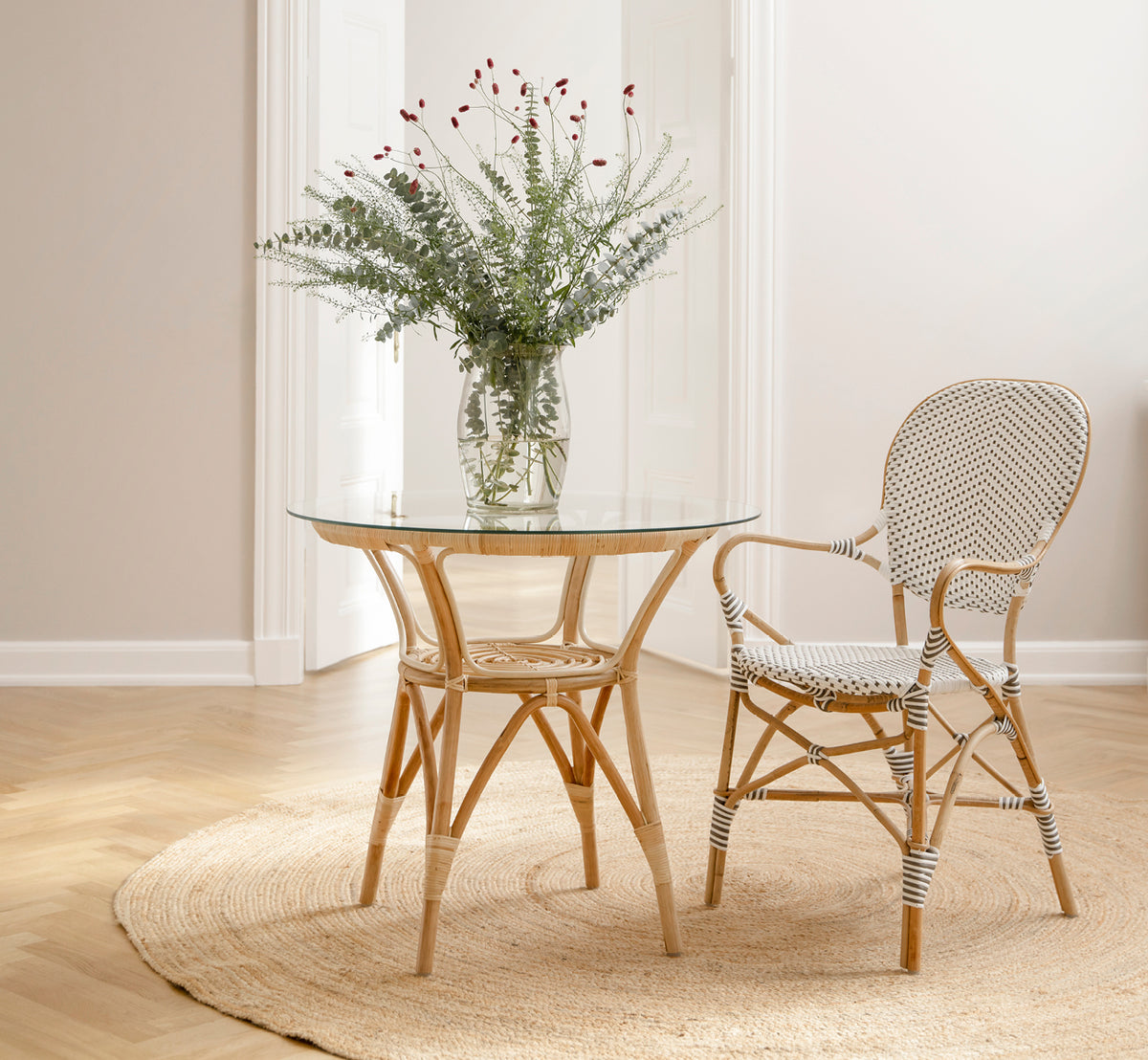 Esta es una imagen de estilo de vida de Isabell sillón de comedor en white w cappuccino dot ArtFibre Skin on Rattan frame, en un luminoso comedor con.