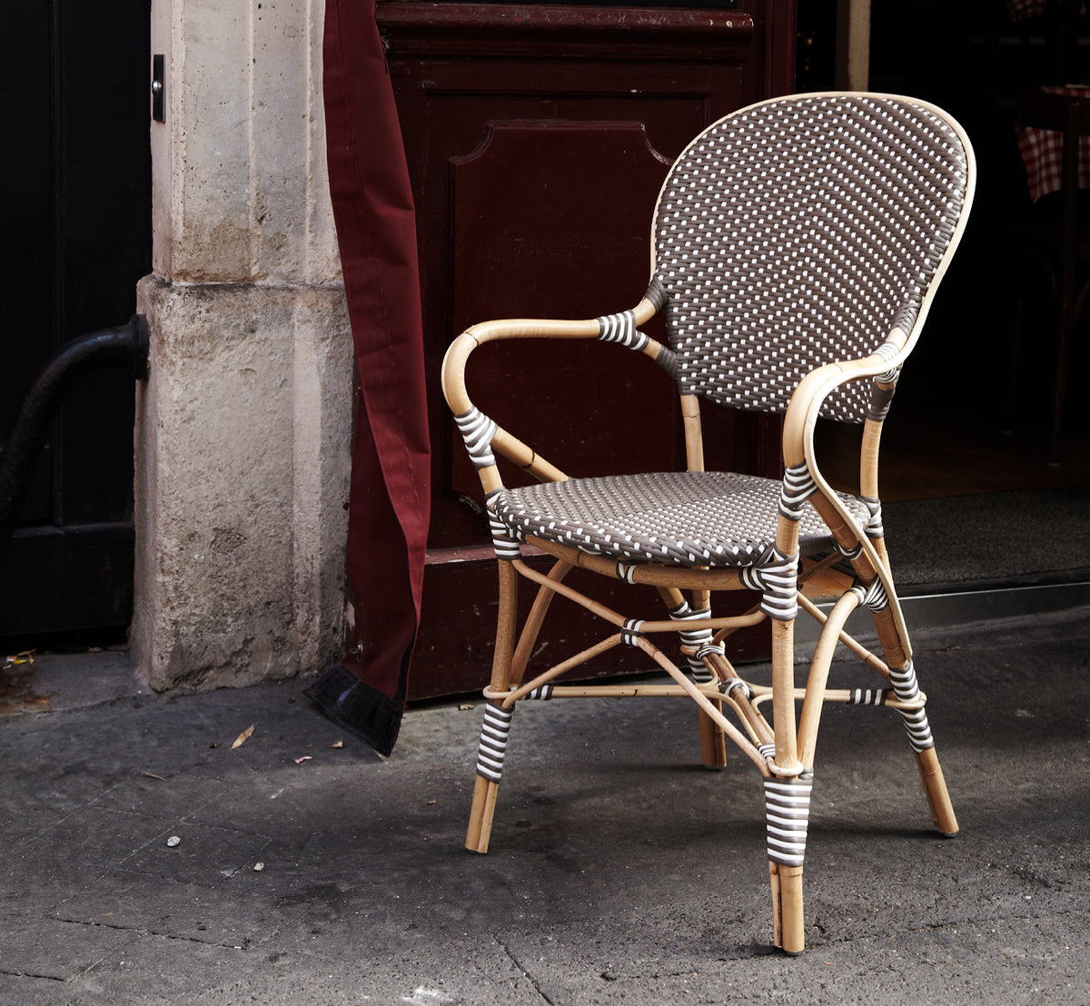 Esta es una imagen de estilo de vida de Isabell sillón de comedor en cappuccino w white dot ArtFibre skin on rattan frame, en un luminoso comedor con.