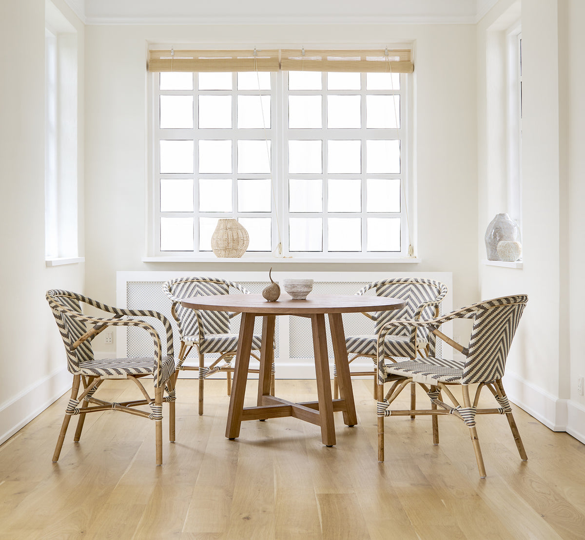 Esta es una imagen de estilo de vida de Madeleine silla de comedor en chevron cappuccino ivory ArtFibre skin on rattan frame. Comedor blanco con suelo de roble.
