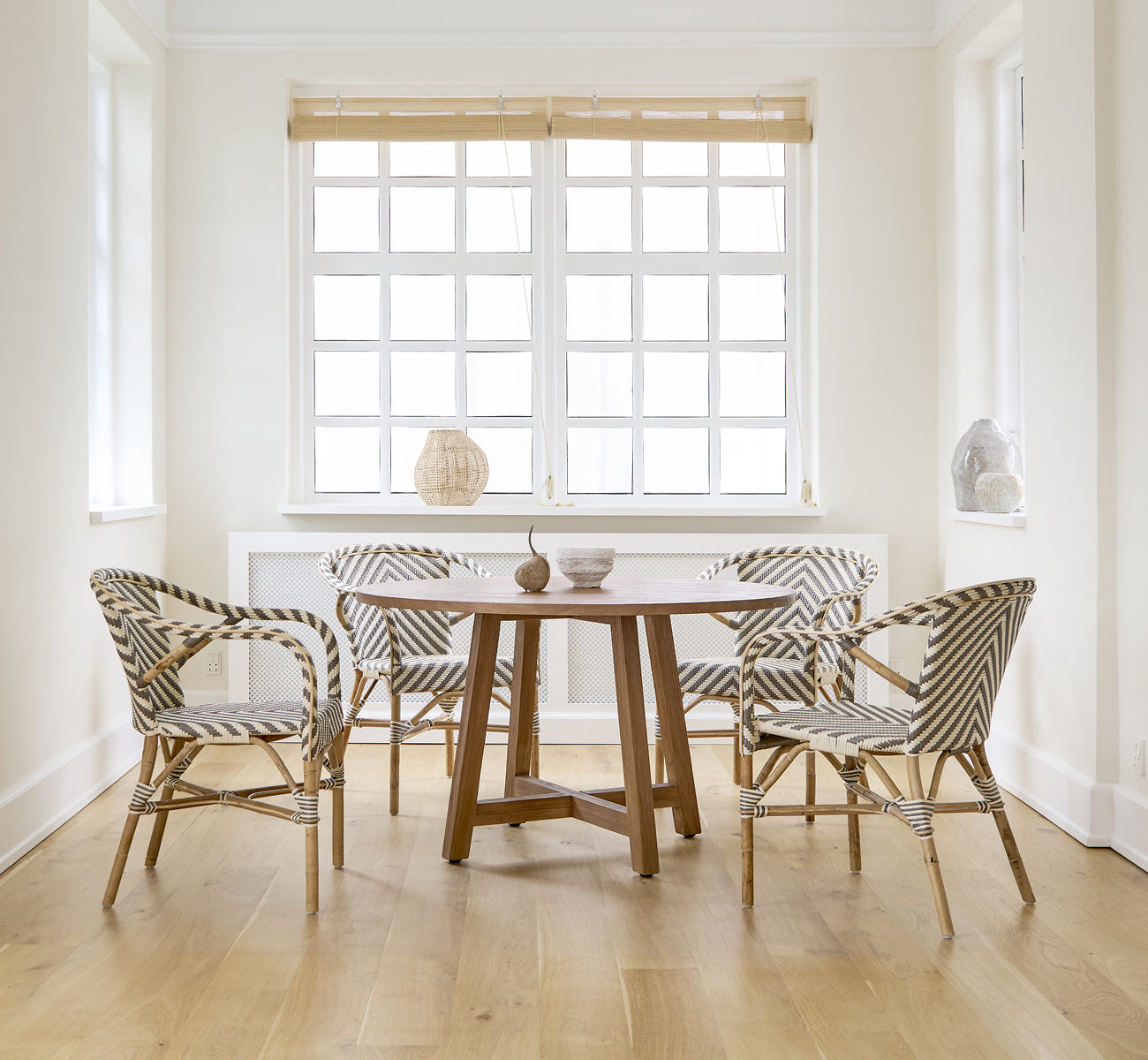Esta es una imagen de estilo de vida de Madeleine silla de comedor en chevron cappuccino ivory ArtFibre skin on rattan frame. Comedor blanco con suelo de roble.