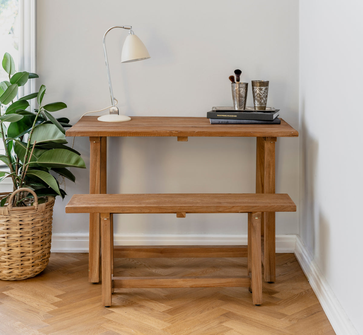 Esta es una imagen de estilo de vida de Lucas Teak banco en teak indoor. Combinado con un escritorio de teca, lámpara y libros en un rincón acogedor sobre suelo en espiga.