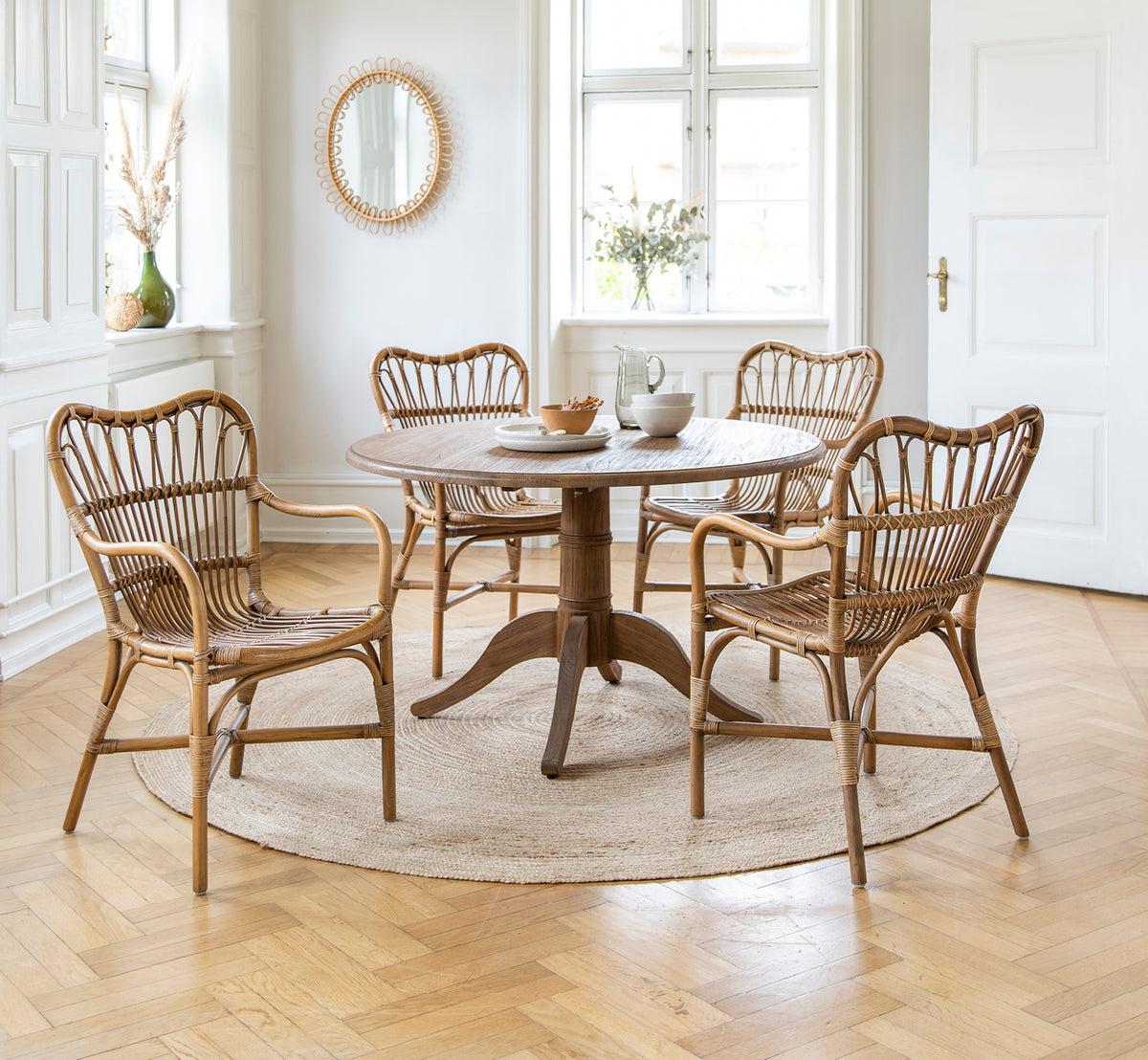 Esta es una imagen de estilo de vida de Michel Teak Dining Table i teak indoor. Con sillas Rossini sobre una alfombra de yute en un loft blanco luminoso.
