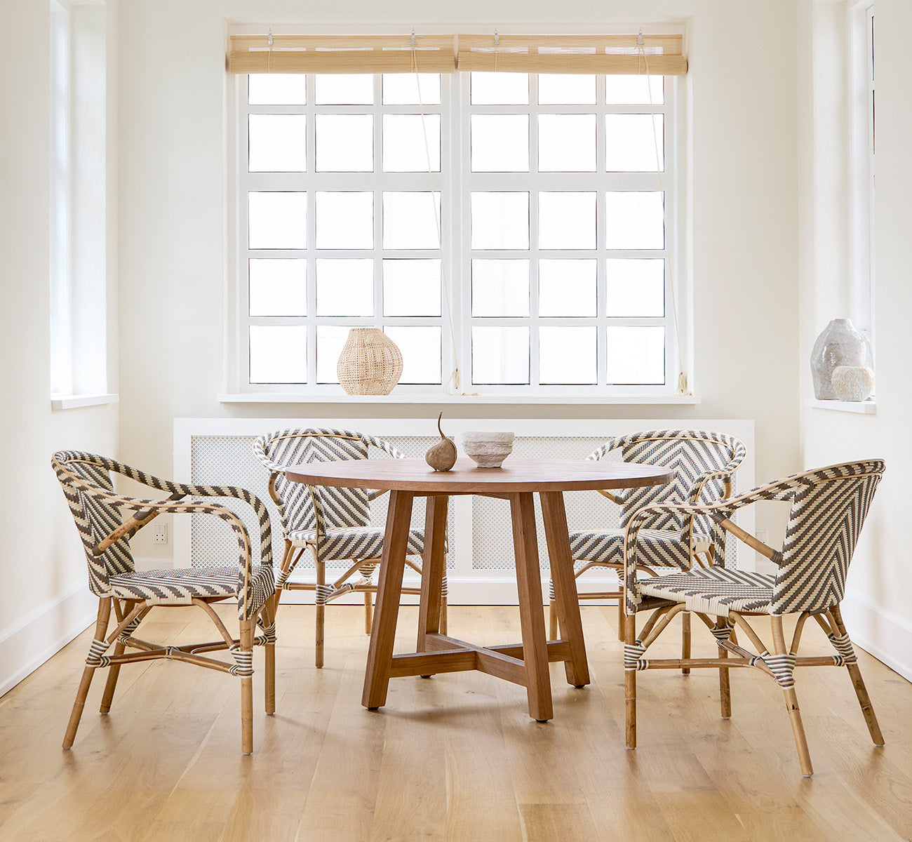 Esta es una imagen de estilo de vida de Aksel mesa de comedor en teak indoor, en un luminoso comedor con grandes ventanas y suelo de madera clara.