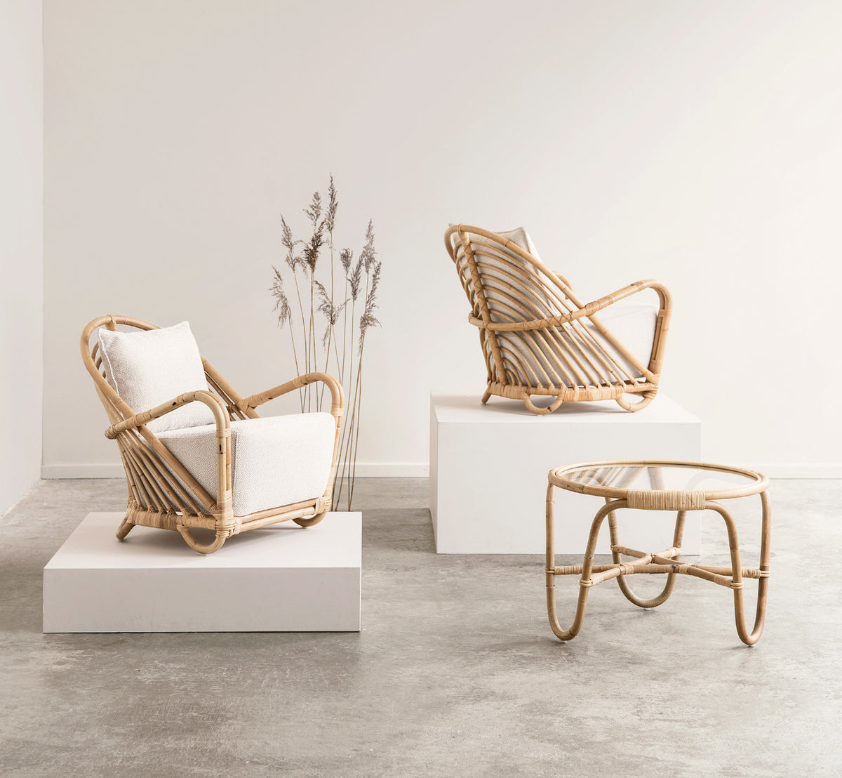 Esta es una imagen de estilo de vida de Charlottenborg sillón lounge en polished Natural Rattan, en un elegante interior clásico con elaboradas.
