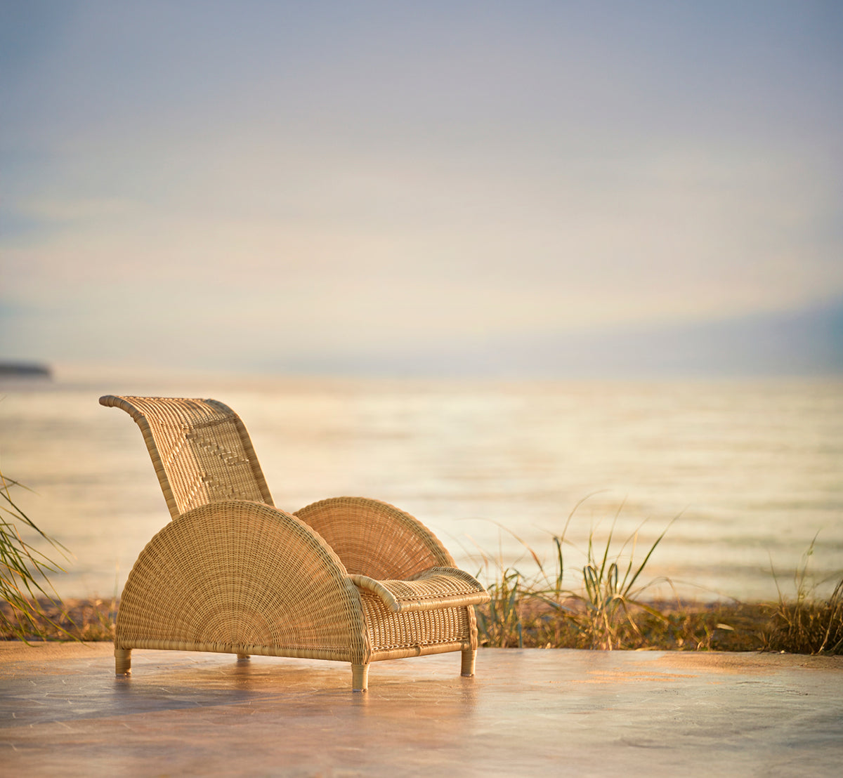 Esta es una imagen de estilo de vida de Paris sillón lounge exterior en natural core weave artfibre aluminium. Estilizado en un interior luminoso.